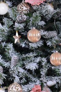 装饰圣诞树关闭。 装饰灯泡雪绿杉树粉红色xMAS玩具和灯。 使用圣诞节和新年庆祝背景