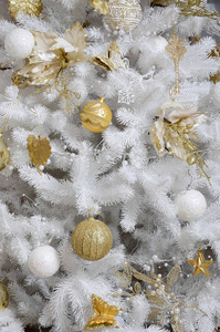 装饰圣诞树关闭。 装饰灯泡，白杉树，金色xMAS玩具和灯。 使用圣诞节和新年庆祝背景