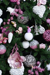 装饰圣诞树关闭。 装饰灯泡，杉树，粉红色的xMAS玩具和灯。 使用圣诞节和新年庆祝背景