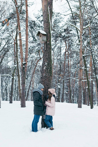 年轻夫妇站在冬林里互相看着