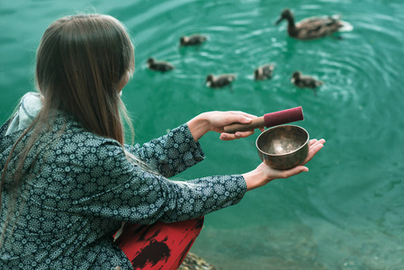 带着藏语唱碗的年轻女子在湖边吸引着鸭家人