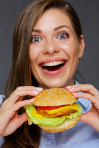 快乐的女人张开嘴拿着大汉堡图片