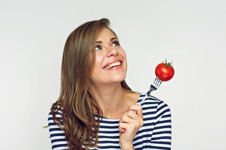 微笑的妇女藏品蕃茄在叉子寻找