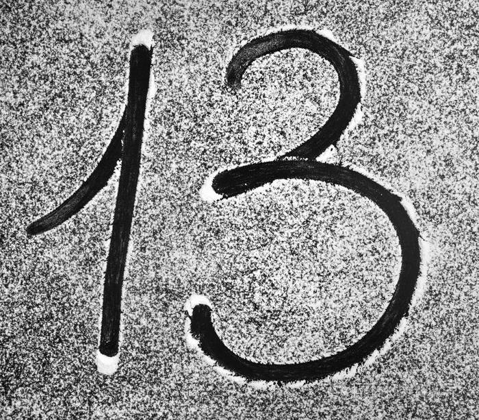 数字13写在洒满白色粉末的黑色背景上