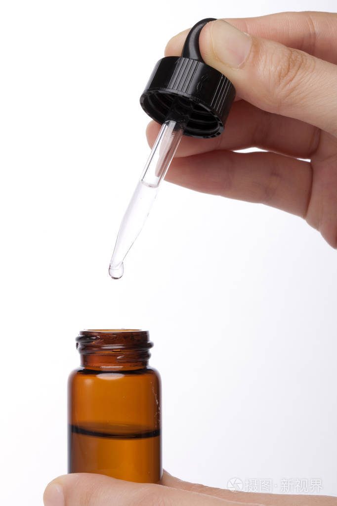 精油从吸管滴到瓶子里精华液化妆品糖浆香水芳香疗法孤立在白色上
