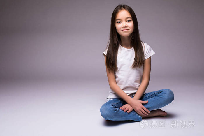 可爱的小女孩坐在地板上白色背景