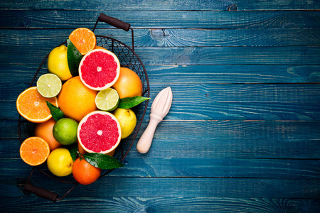 柑橘类水果和烹调柑橘汁的背景。新鲜的柑橘类水果和树叶。橙色, 葡萄柚, 柠檬, 石灰, 橘子在木桌上。健康饮食饮食素食观念
