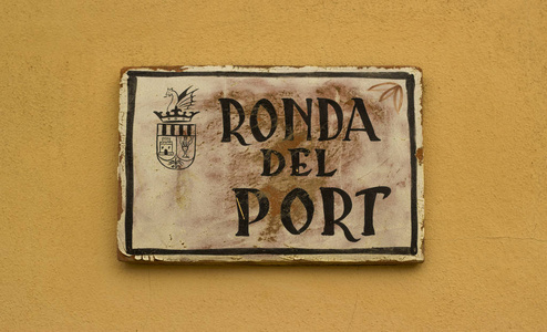 米色墙上的旧西班牙街名牌