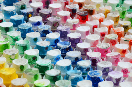 一种图案，来自油漆喷雾器的许多喷嘴，用于绘制涂成不同颜色的涂鸦。 塑料帽排列成多排，形成彩虹的颜色