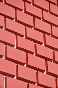 装饰混凝土墙,浮雕类似于用鲜红色油漆粉刷的大砖砌体照片