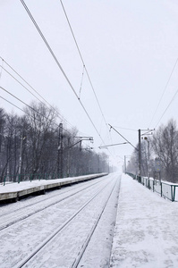 冬季寒冷季节的铁路景观。 大雪覆盖了火车站站台和浓雾笼罩的天空