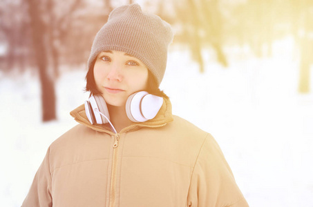 美丽迷人的白种人穿孔女孩希普斯特冬季公园的肖像。 她正在耳机上听音乐。 青年街头时尚。 冬天的乐趣。