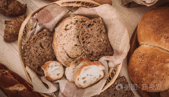 许多混合的烘烤面包和卷在质朴的木桌