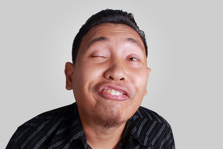 不寻常的面部表情亚裔男子表现出可笑的面部表情照片