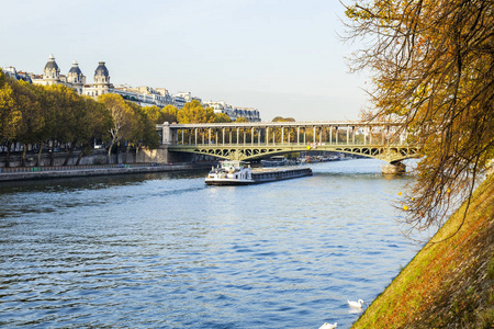 巴黎法国2017年10月30日秋季城市景观。 夕阳照亮了塞纳河及其河堤。 两级伯哈基姆桥在远处。