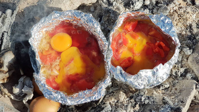 在海滩上的火上用铝箔煮鸡蛋