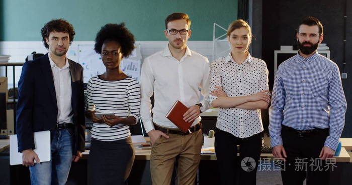 年轻的多商业团队的肖像拍摄, 站在现代办公室。男性和女性的办公室工作人员。室内