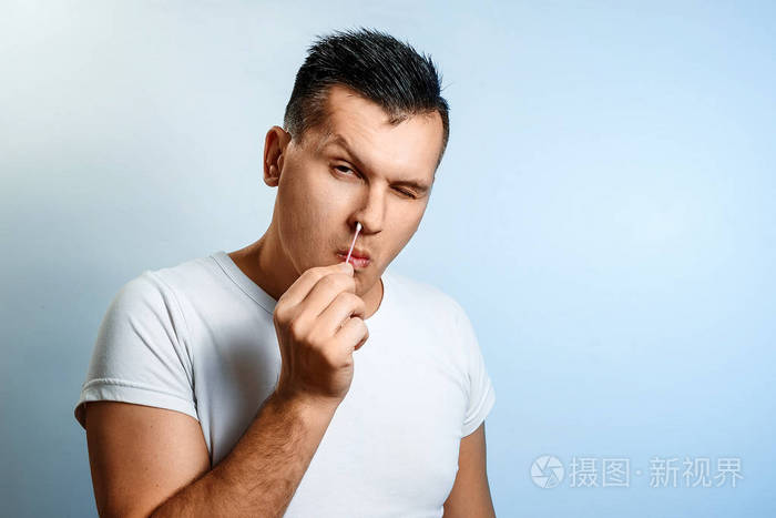那个人用棉签在浅色背景上抠鼻子身体卫生