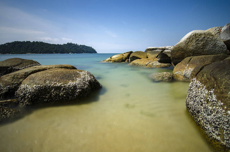 田园诗般的热带岛屿风景的长曝光镜头，晶莹剔透的绿松石水和蓝天背景。