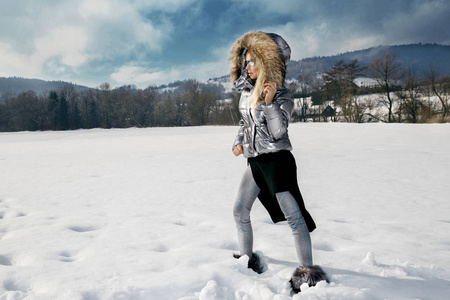 美丽的年轻女子穿着冬天的滑雪服，背景是山脉。 美丽的冬景。