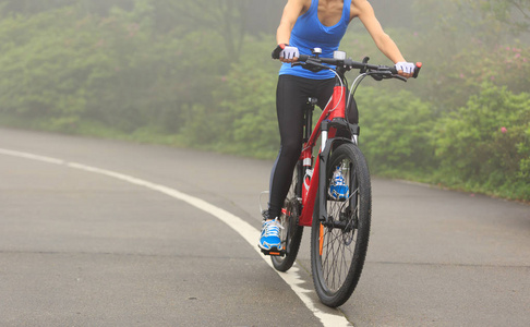 年轻女子骑自行车在小径上骑山地自行车