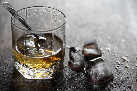 在玻璃和在木头上的冰块的威士忌