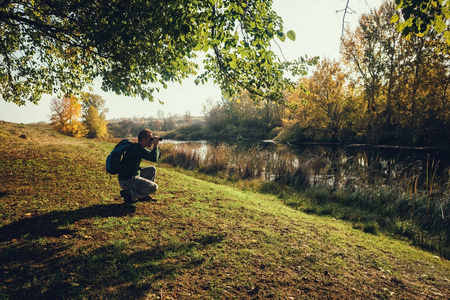 秋天，人们用望远镜在河边看鸟。