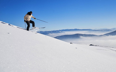 滑雪巡回赛男子在瑞士阿尔卑斯山日出时到达山顶。