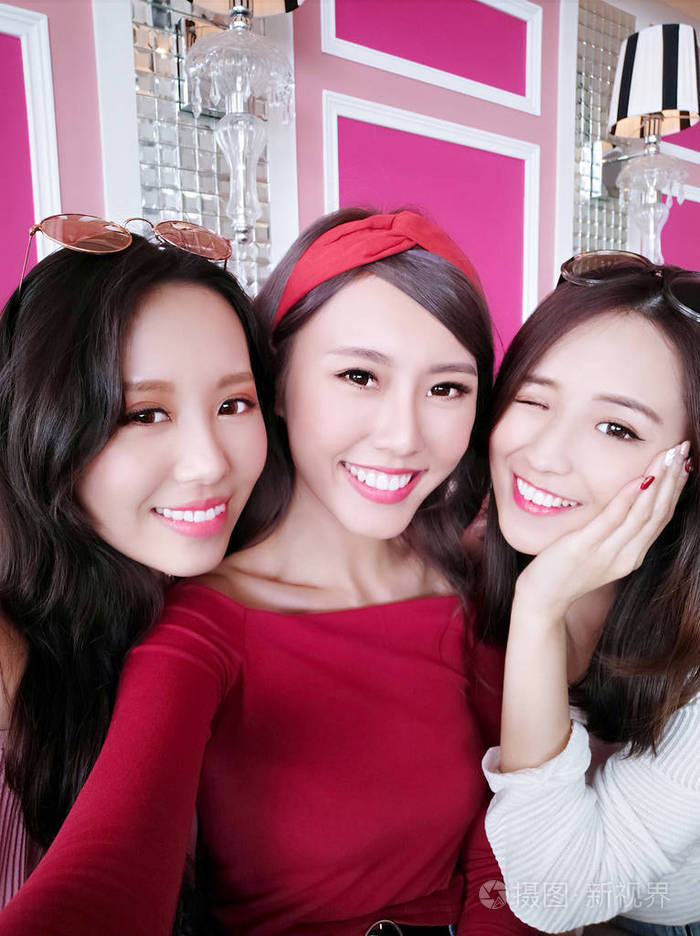 三位美女在餐馆里快乐地自拍