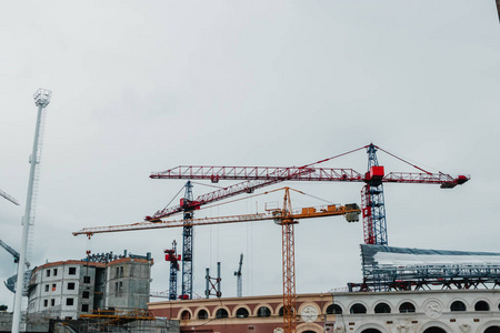 大型工业塔式起重机,未完成的高层建筑和蓝天背景. 脚手架.