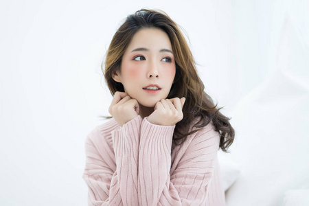 年轻快乐美丽的亚洲女孩穿着毛衣粉红色冷