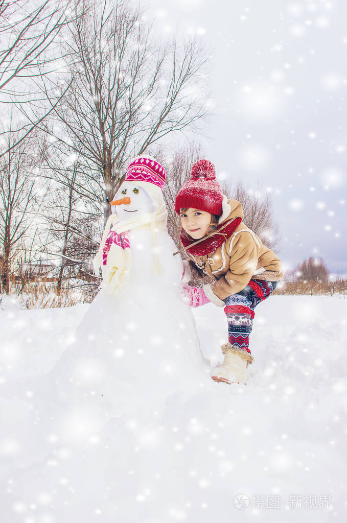 冬天在雪地里的孩子堆雪人选择性聚焦