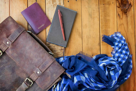 皮革棕色袋护照和笔记本与海军蓝色检查围巾