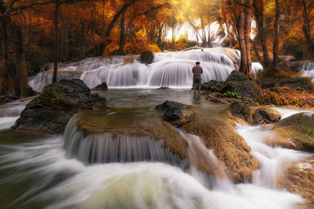 摄影师拍摄美丽的瀑布在深林下瀑布kanchanaburi省泰国自然旅游概念