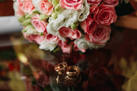 新娘早晨戴着新娘花束的结婚戒指。