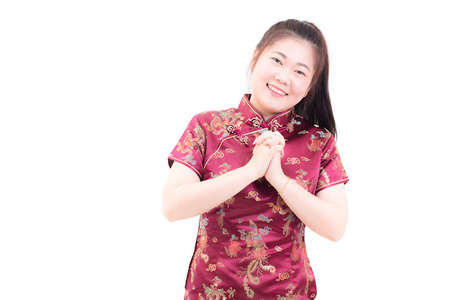 身穿中式旗袍的年轻亚裔女子, 带着祝贺的姿态, 在中国新年庆典上看着镜头微笑, 在白色背景下庆祝新年
