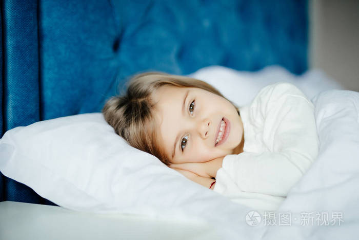 健康和美丽概念-小女孩睡在家里微笑在她的床照片-正版商用图片10ryiq