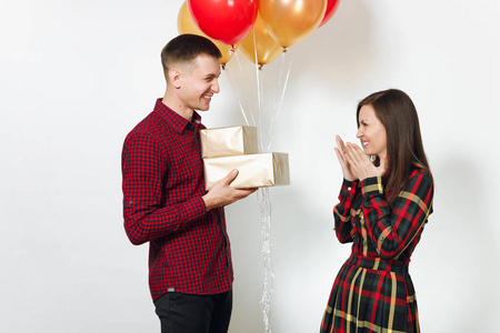 美丽的年轻幸福的微笑情侣在爱。妇女和人拿着礼物和红色的金黄礼物箱子, 黄色气球, 庆祝生日, 在白色背景隔绝了。假日, 党概念