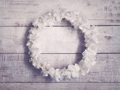 防腐木花架木头背景上的白色花圈. 圆形花架用于婚礼装饰.