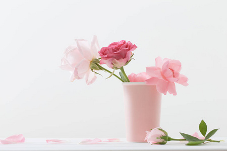 在白色背景上的花瓶粉红玫瑰