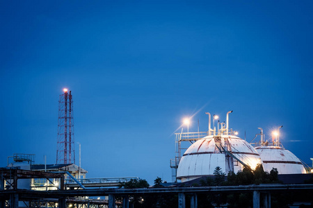 黄昏工程在黄昏的天空背景下,装有储气罐的石化工业工厂照片