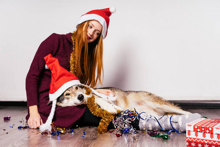 可爱的 redhaired 女孩与她的狗庆祝圣诞节和新年