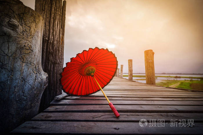 在缅甸曼德勒的日出桥上的红色雨伞