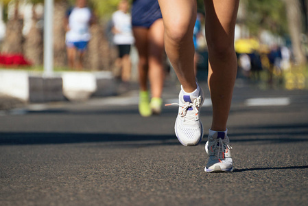 跑在城市道路上的马拉松运动员腿上的细节