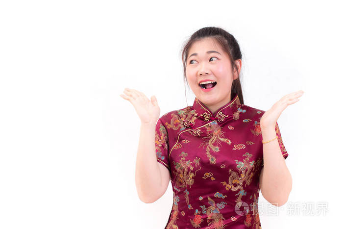 年轻的亚裔女子身穿中式旗袍, 带着惊讶兴奋的快乐尖叫和微笑。在农历新年庆典上, 在白色背景下庆祝新年