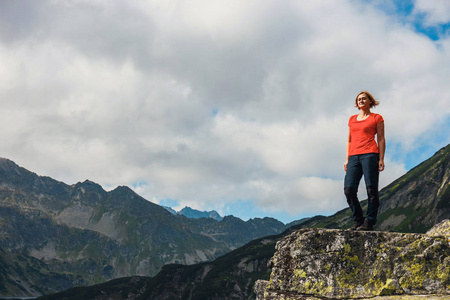 女人站在悬崖上, 看着山顶
