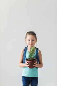 女孩站在白色的背景与植物的世界地球日