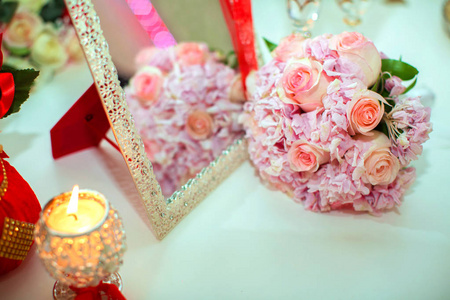 婚礼花束粉红色玫瑰和结婚戒指在一个木桌上。复制空间。婚礼聚会爱情家庭和戒指的概念