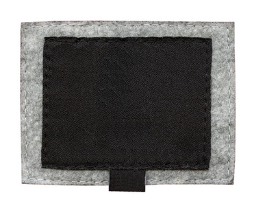 灰色纺织背景下的空白黑色织物标签