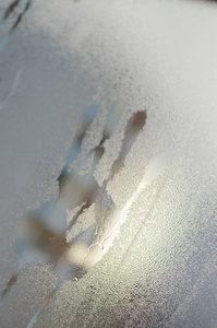 在窗户玻璃上用凝结雨水或水滴和蒸汽表面纹理提取背景的手掌印痕特写